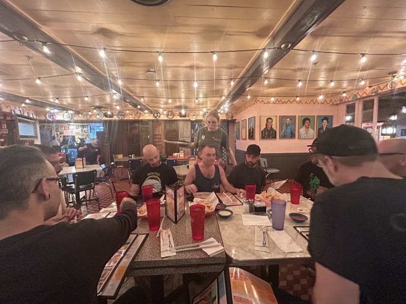 The touring party seated around a table at a restaurant