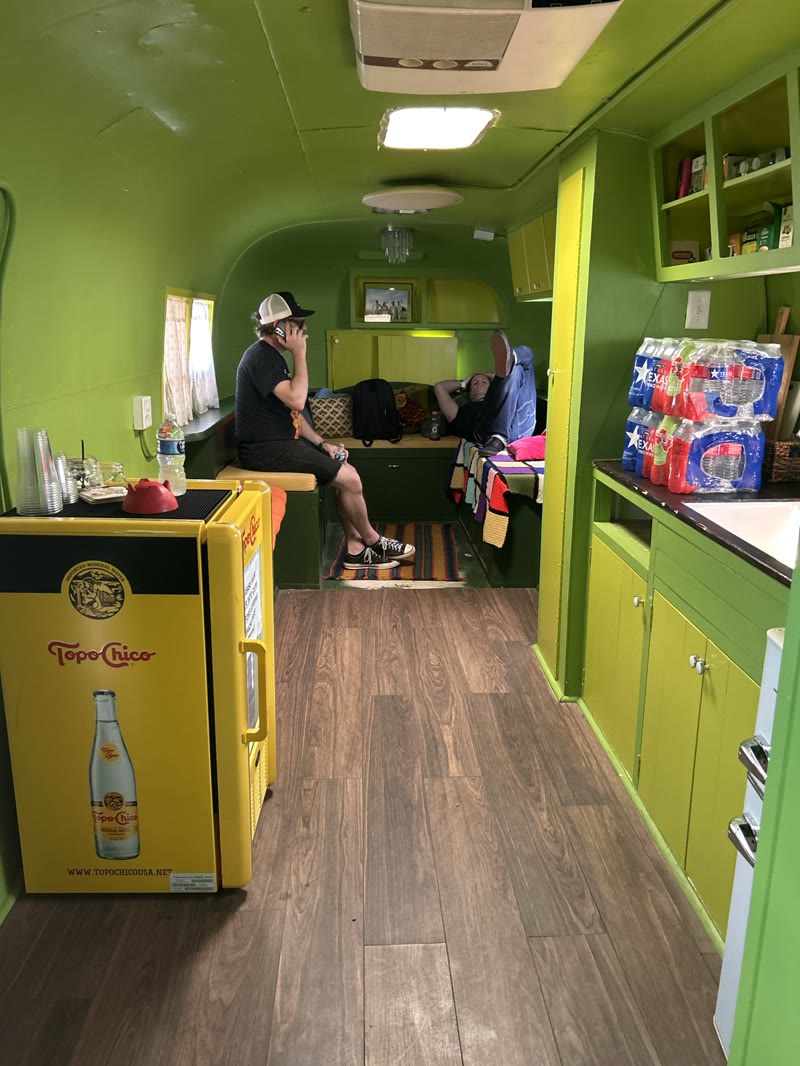 Two members of the touring party resting inside a bright green trailer